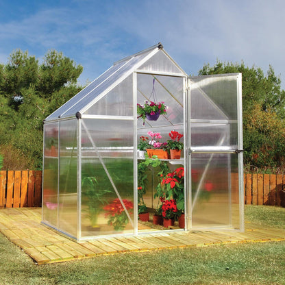 A greenhouse made up of windows with silver metal framing